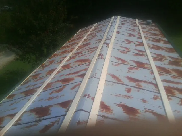 Rusted metal roof panels with new wood purlins before replacement — Storm Damage Roof Repair in Coal Creek by Roofing Brothers